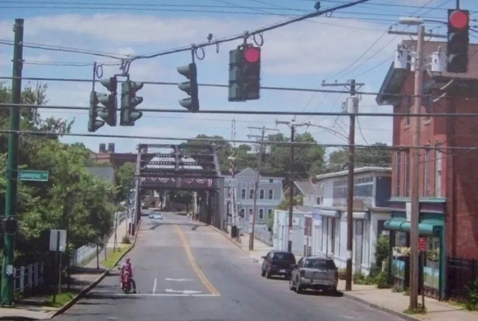 Street view with red traffic lights and bridge in the background
